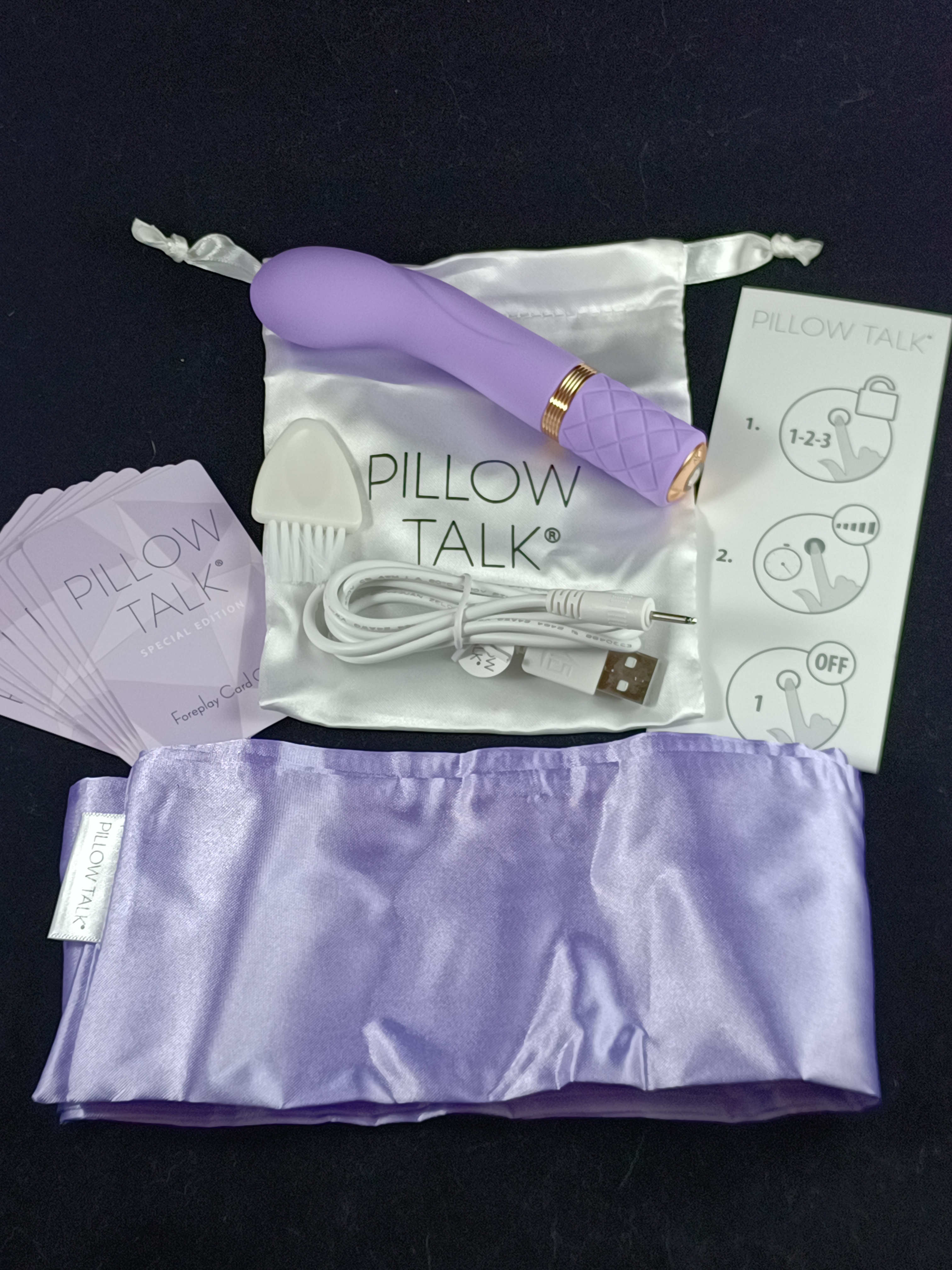 Pictured is the Pillow Talk Racy kit, equipped with a charger, cleaning tool, instructions, cards, blindfold, and toy. Pictured is the Pillow Talk Racy kit, equipped with a charger, cleaning tool, instructions, cards, blindfold, and toy.