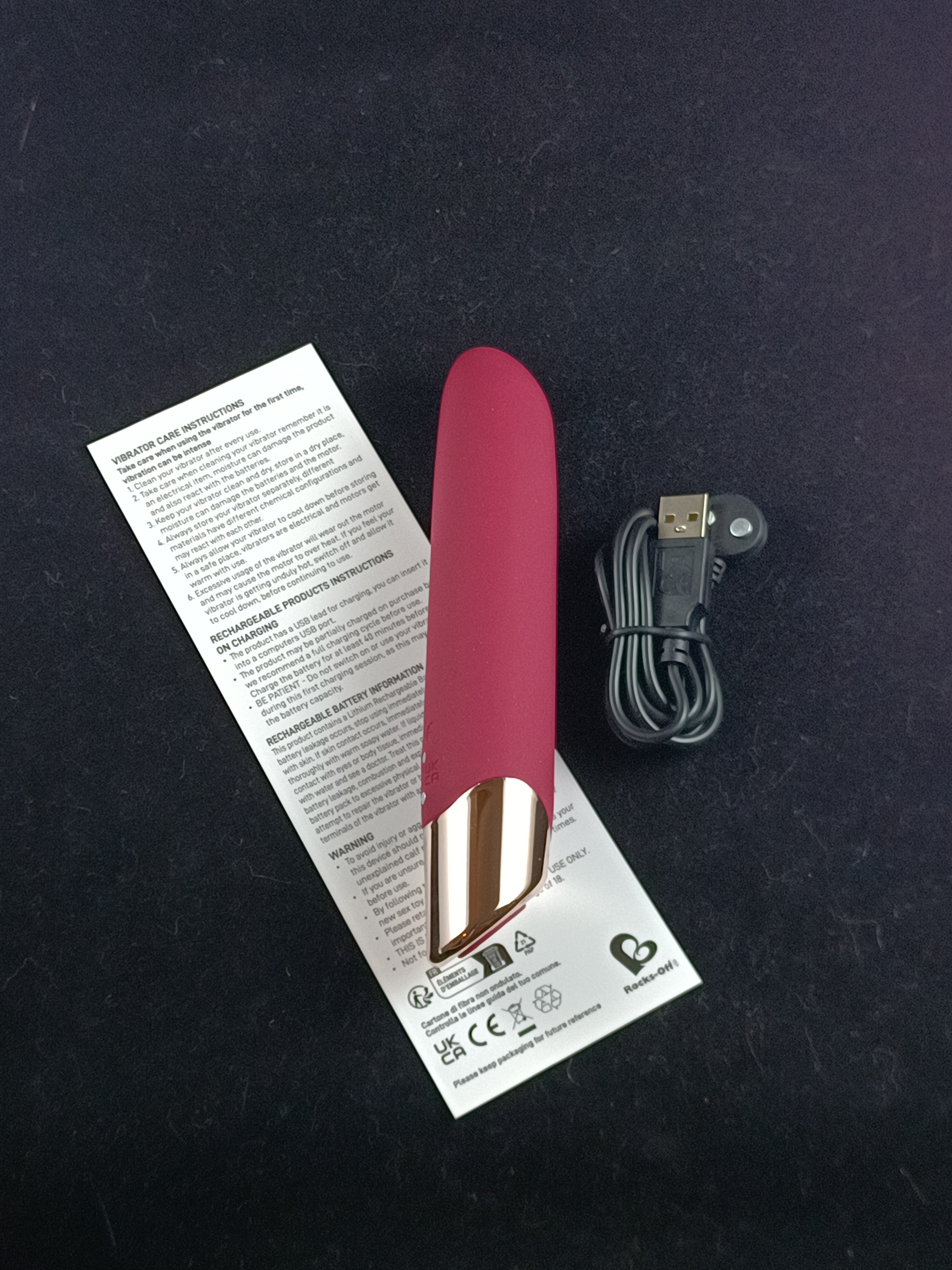 Pictured is the Rocks-Off Chaiamo Vibrator, charger, and instruction sheet. Pictured is the Rocks-Off Chaiamo Vibrator, charger, and instruction sheet.