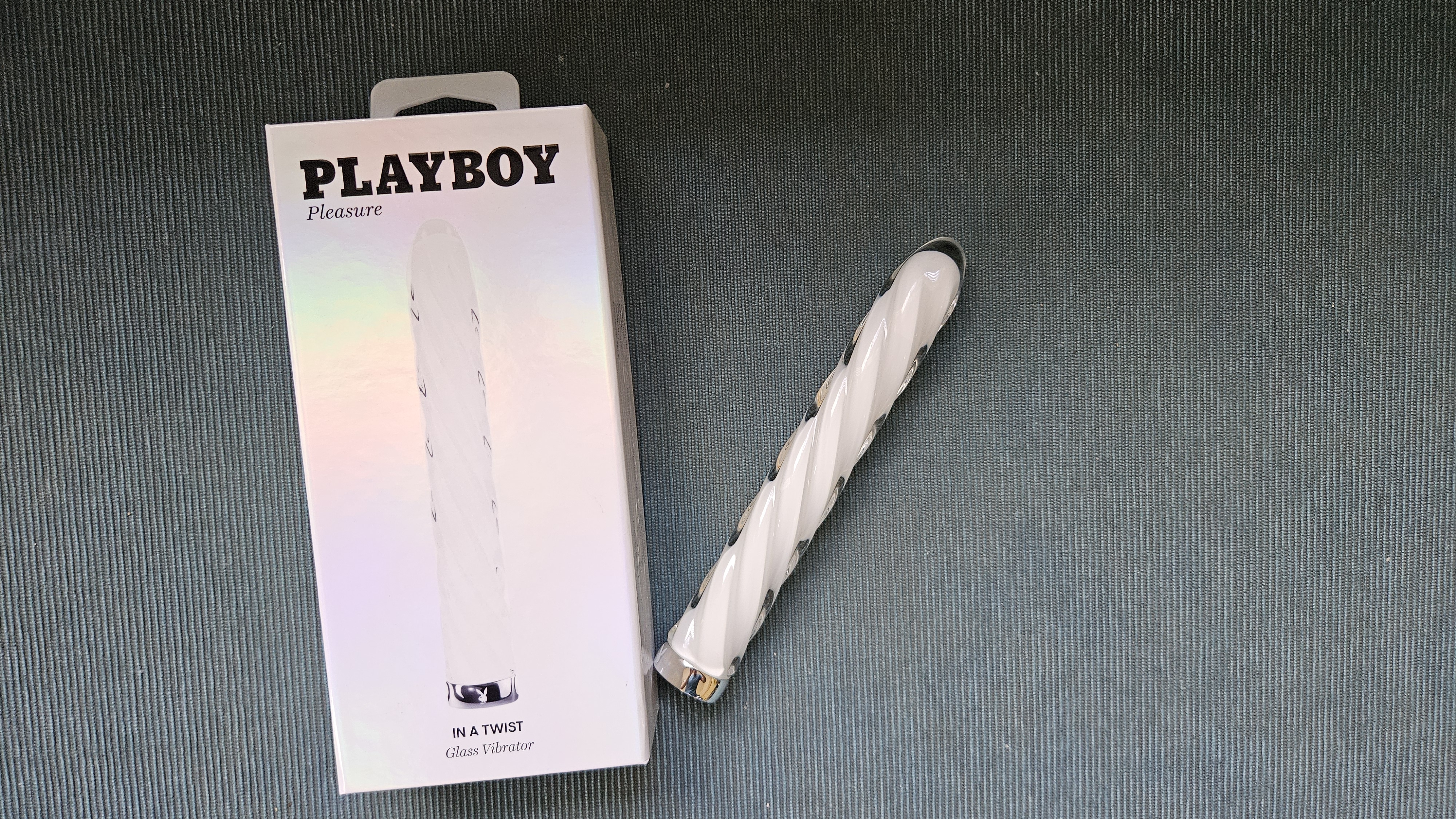 Playboy Pleasure In A Twist Glass Vibrator featured next to the box for reference.