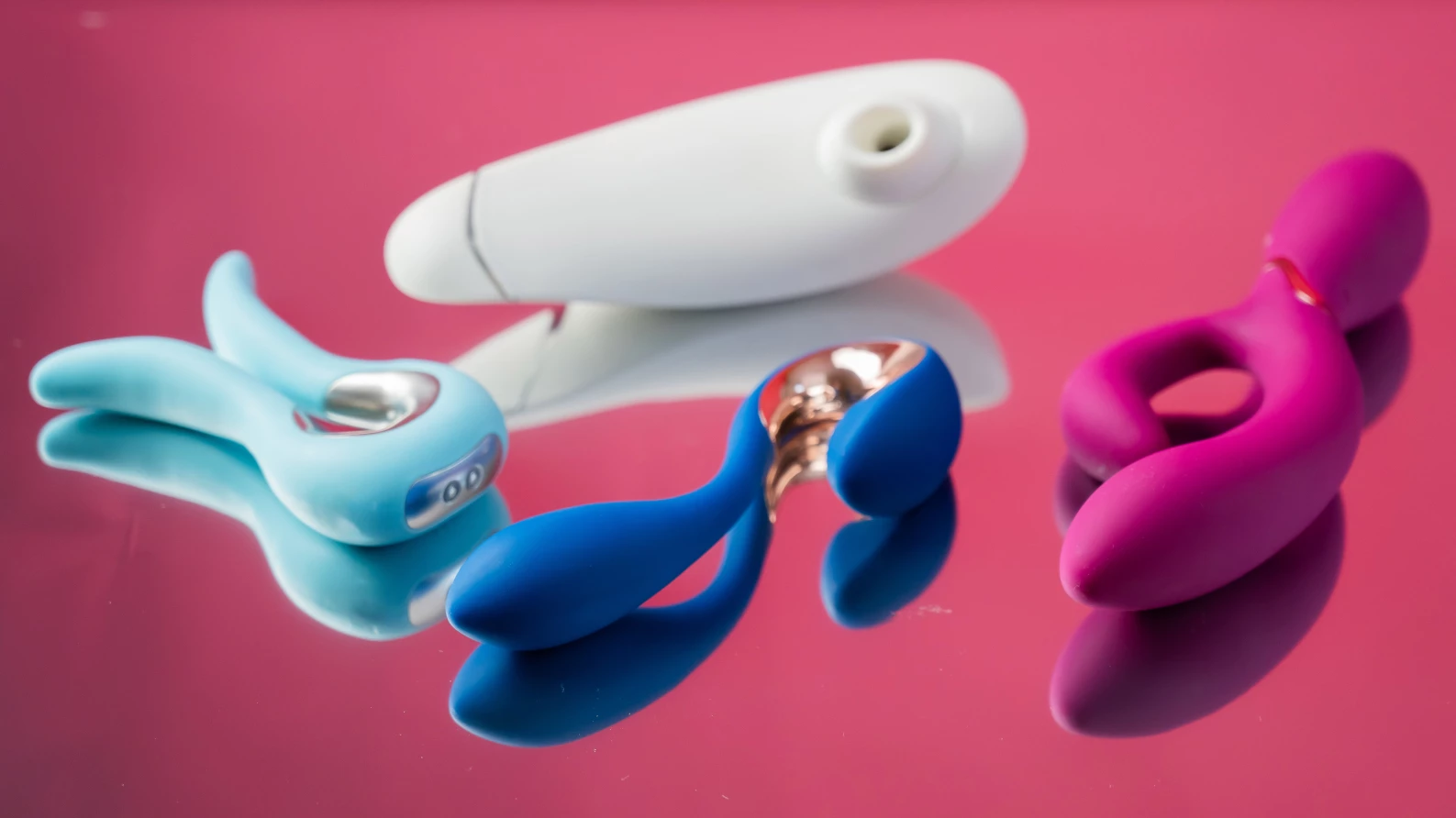 Four clean sex toys on top of a mirror.