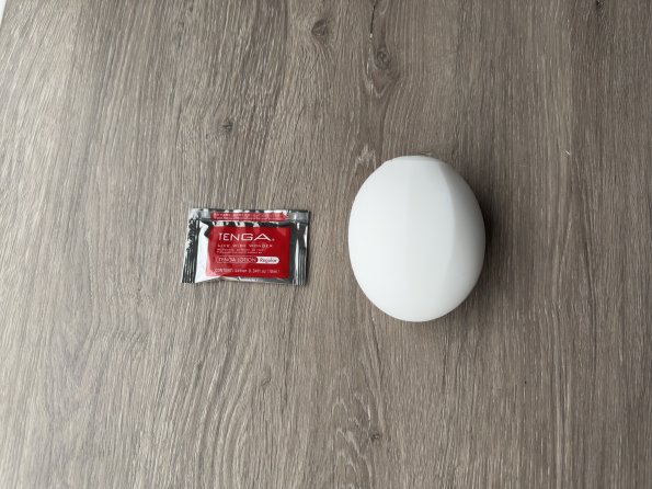 Pictured is the Tenga Geo Coral penis toy next to the lube packet that is included in the delivery.