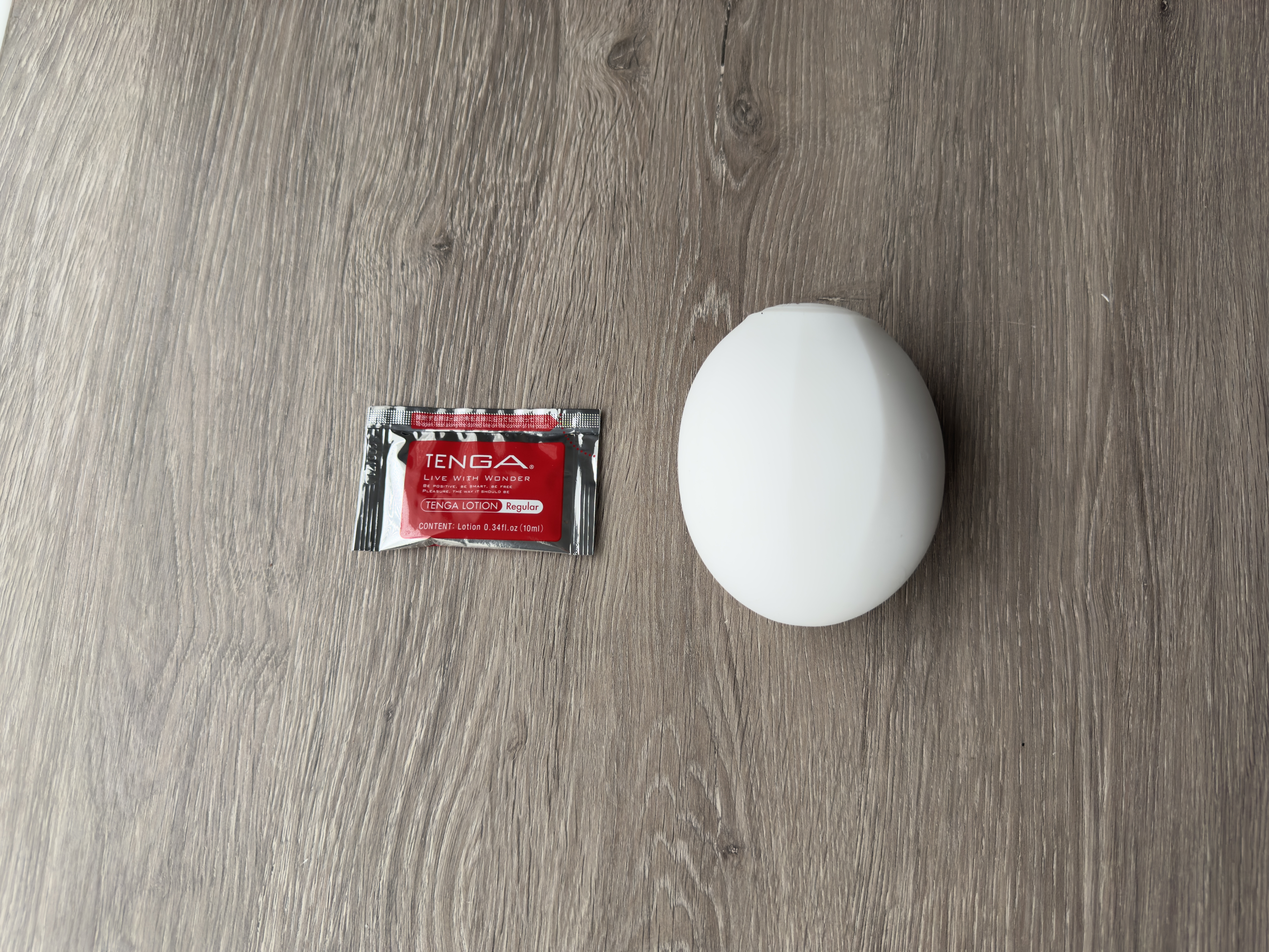 Pictured is the Tenga Geo Coral penis toy next to the lube packet that is included in the delivery. Pictured is the Tenga Geo Coral penis toy next to the lube packet that is included in the delivery.