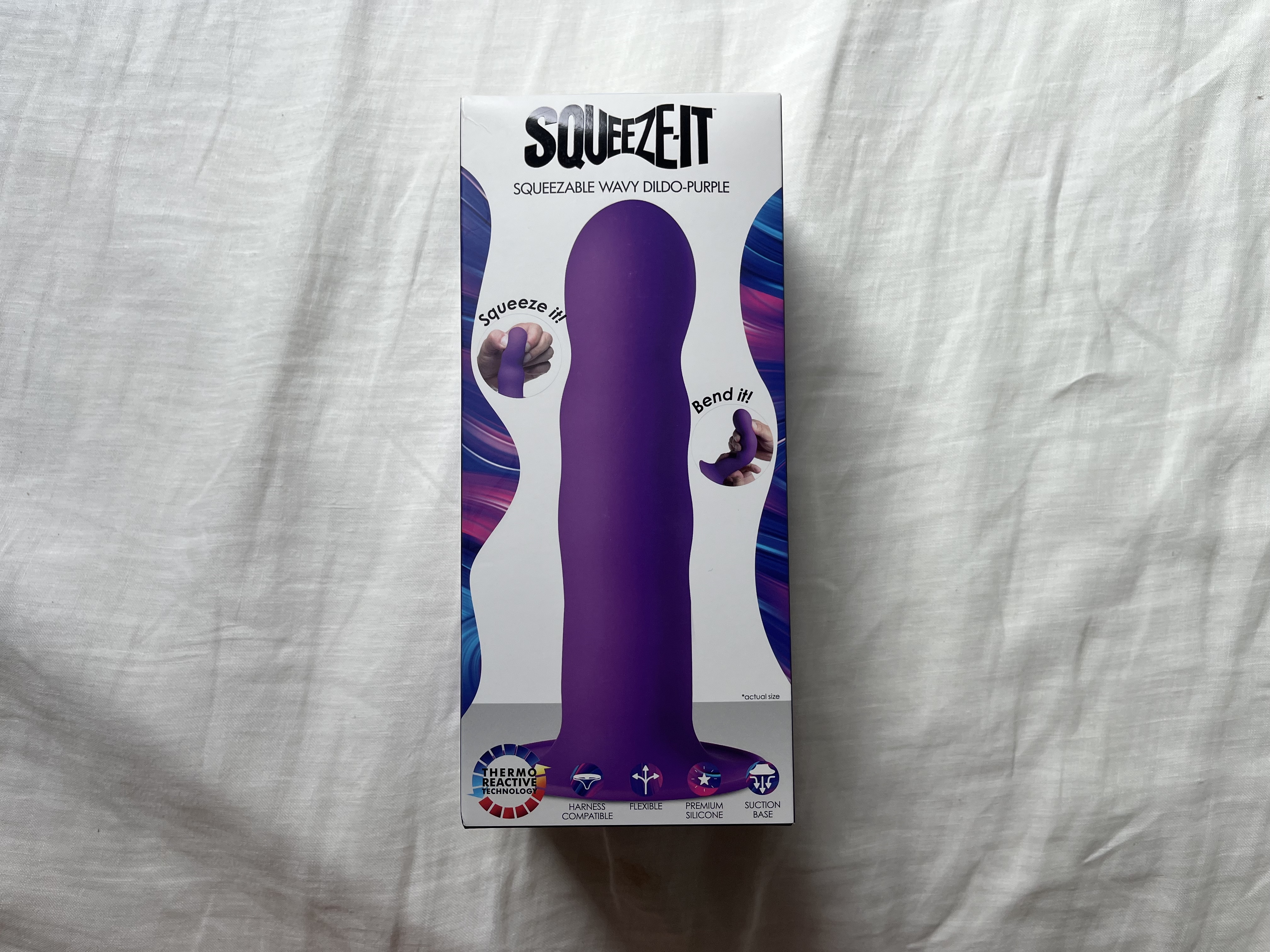Pictured is the Squeeze-It Wavy Dildo in its packaging. Pictured is the Squeeze-It Wavy Dildo in its packaging.