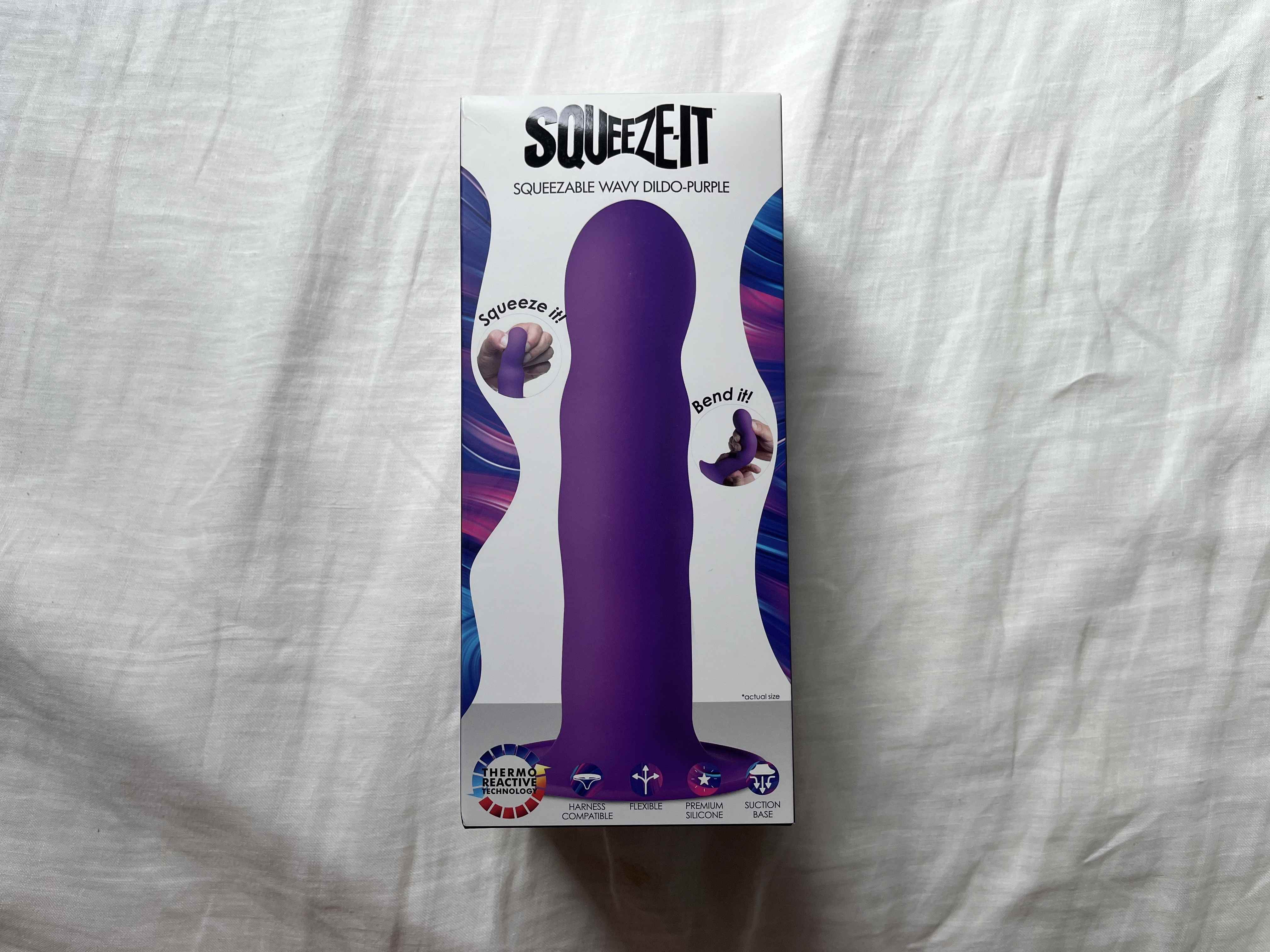Pictured is the Squeeze-It Wavy Dildo in its packaging. Pictured is the Squeeze-It Wavy Dildo in its packaging.