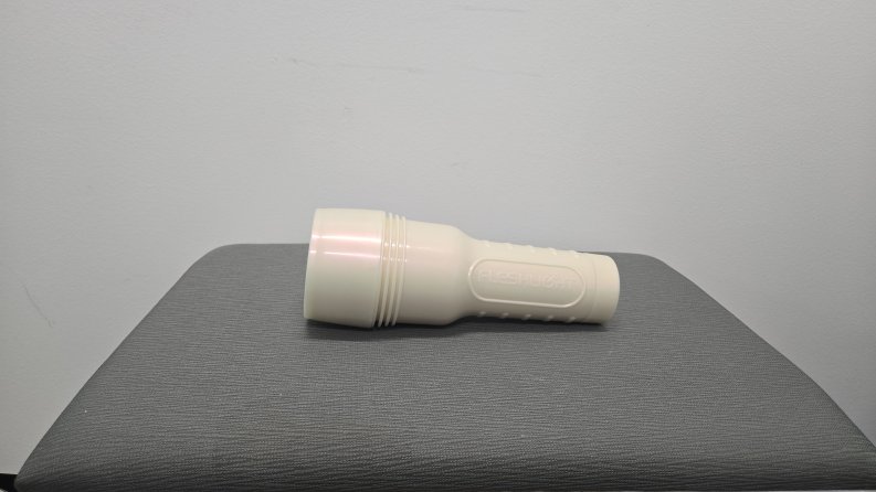 A Fleshlight lays flat with its case shown to the camera.