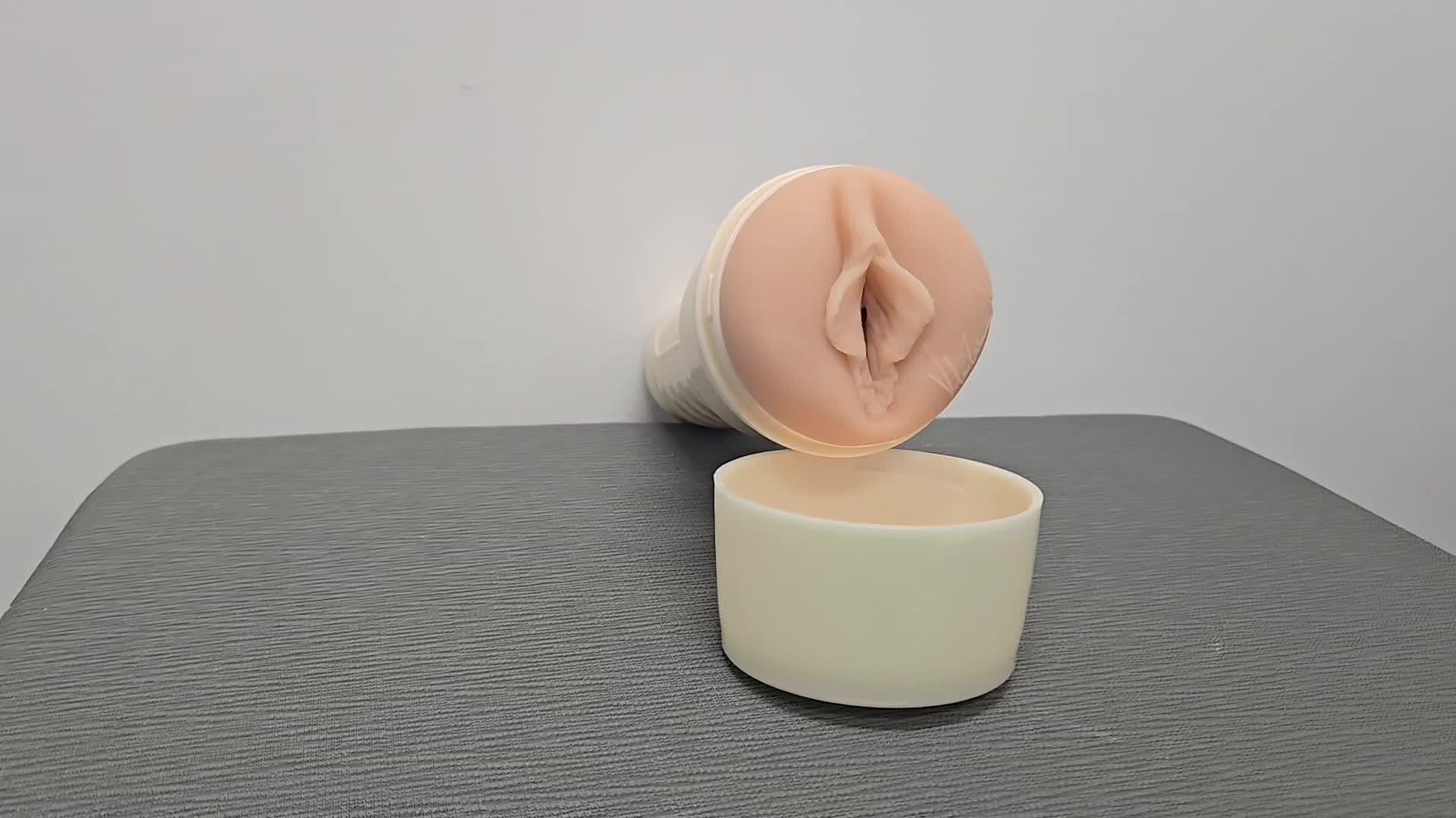 Video of the Valentina Nappi Fleshlight sex toy lays flat on a gray surface while the camera pans around it.